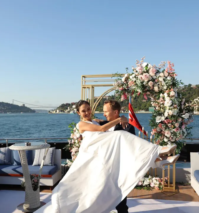 Yatta çiçek takının önünde gelin ve damat